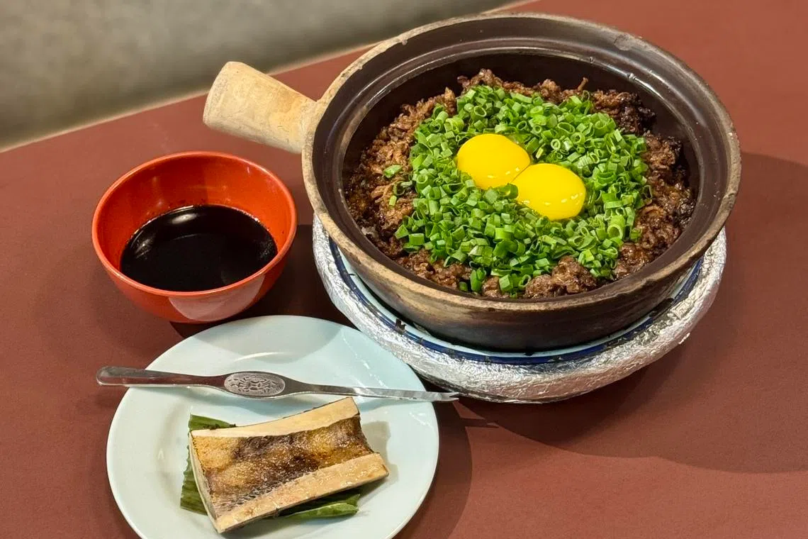 芽笼砂煲饭的牛骨髓砂煲饭，以五花牛肉、蛋黄、黑酱油和剖半牛骨髓，吃出砂煲饭新滋味。（餐馆提供）