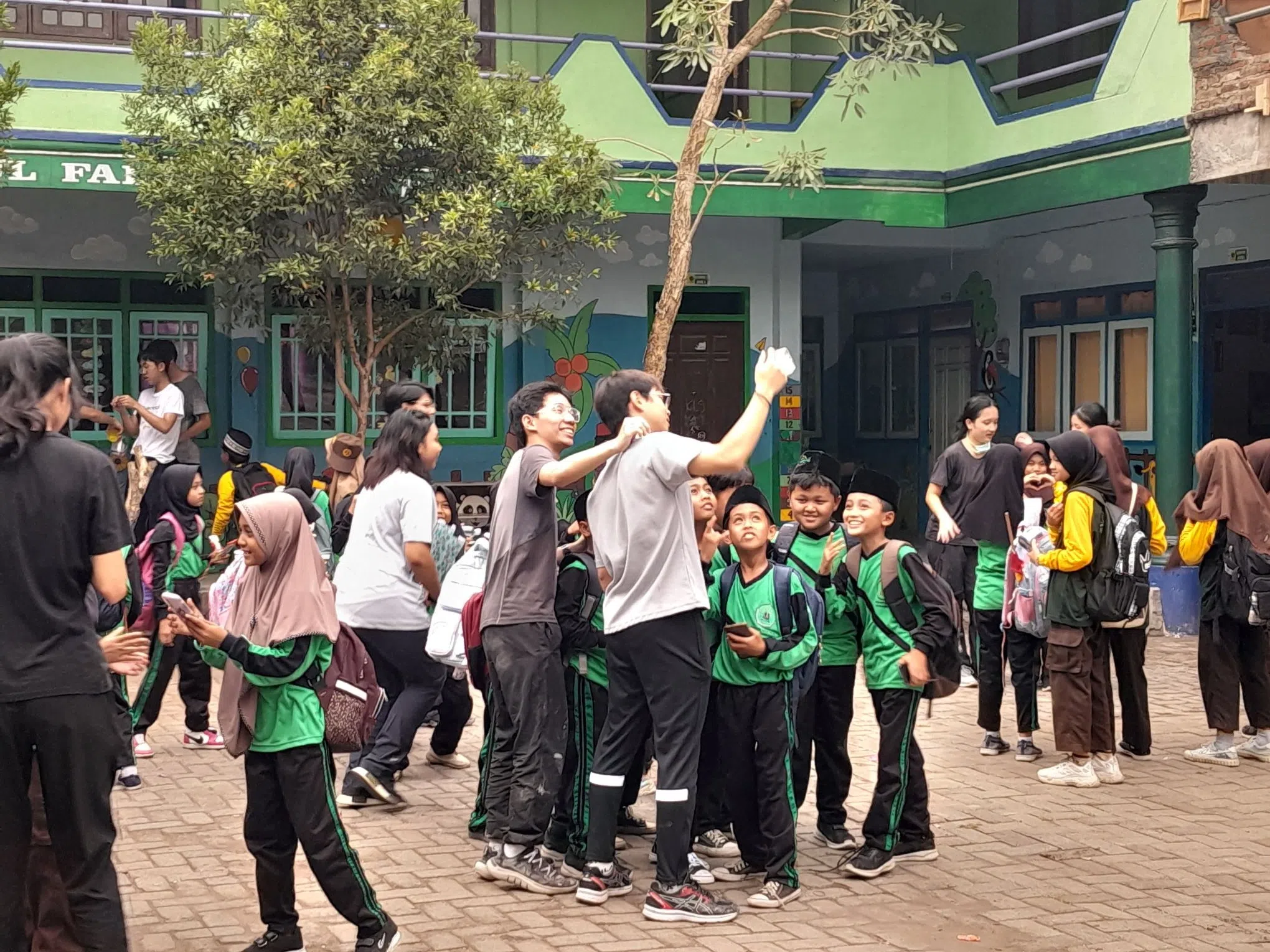 小学生在回家前热情地提出合影的请求，希望留住珍贵的回忆。（华侨中学郑哲宏摄）