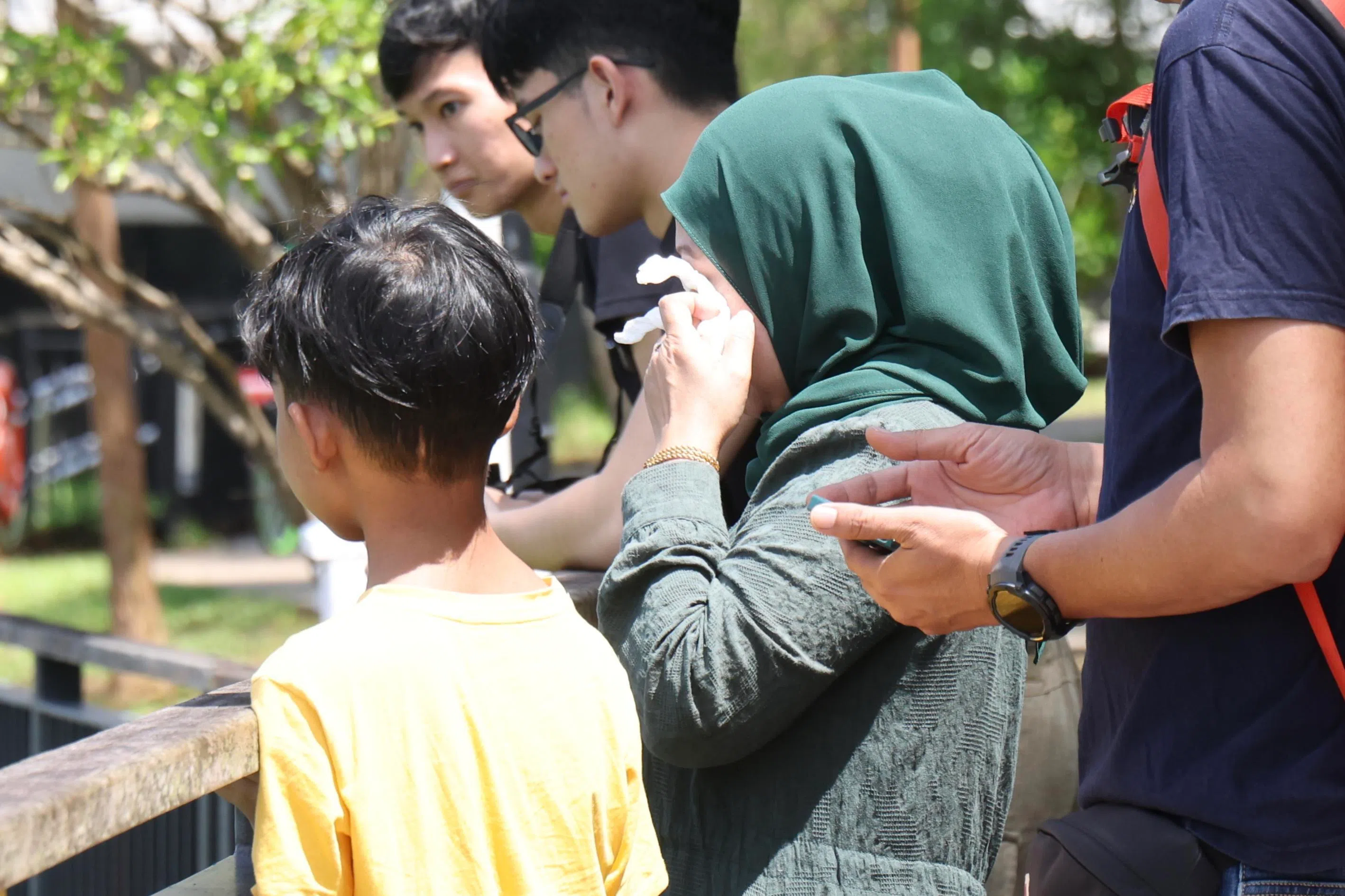 西蒂带着另两个儿子到现场等待，时不时用纸巾擦干眼泪。（郑一鸣摄）