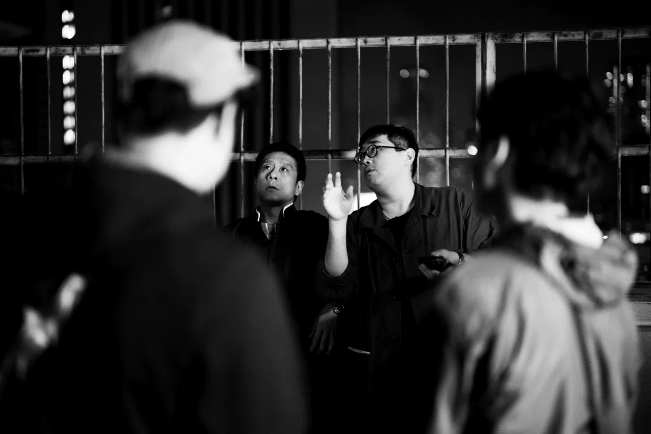 《破·地狱》导演陈茂贤（面对镜头右）和朱柏康讲戏。（新加坡电影协会提供）