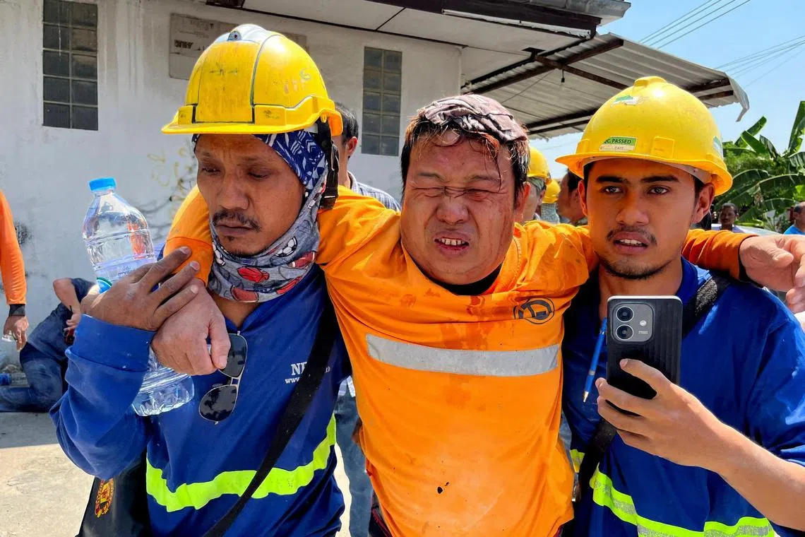 缅甸中部发生强烈地震，工作人员救助一名受伤男子。（路透社）