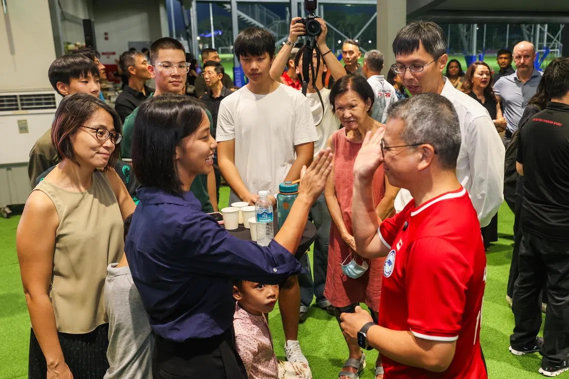 文化、社区及青年部长兼律政部第二部长唐振辉（右）与学生运动员韩恩互动。（白艳琳摄）