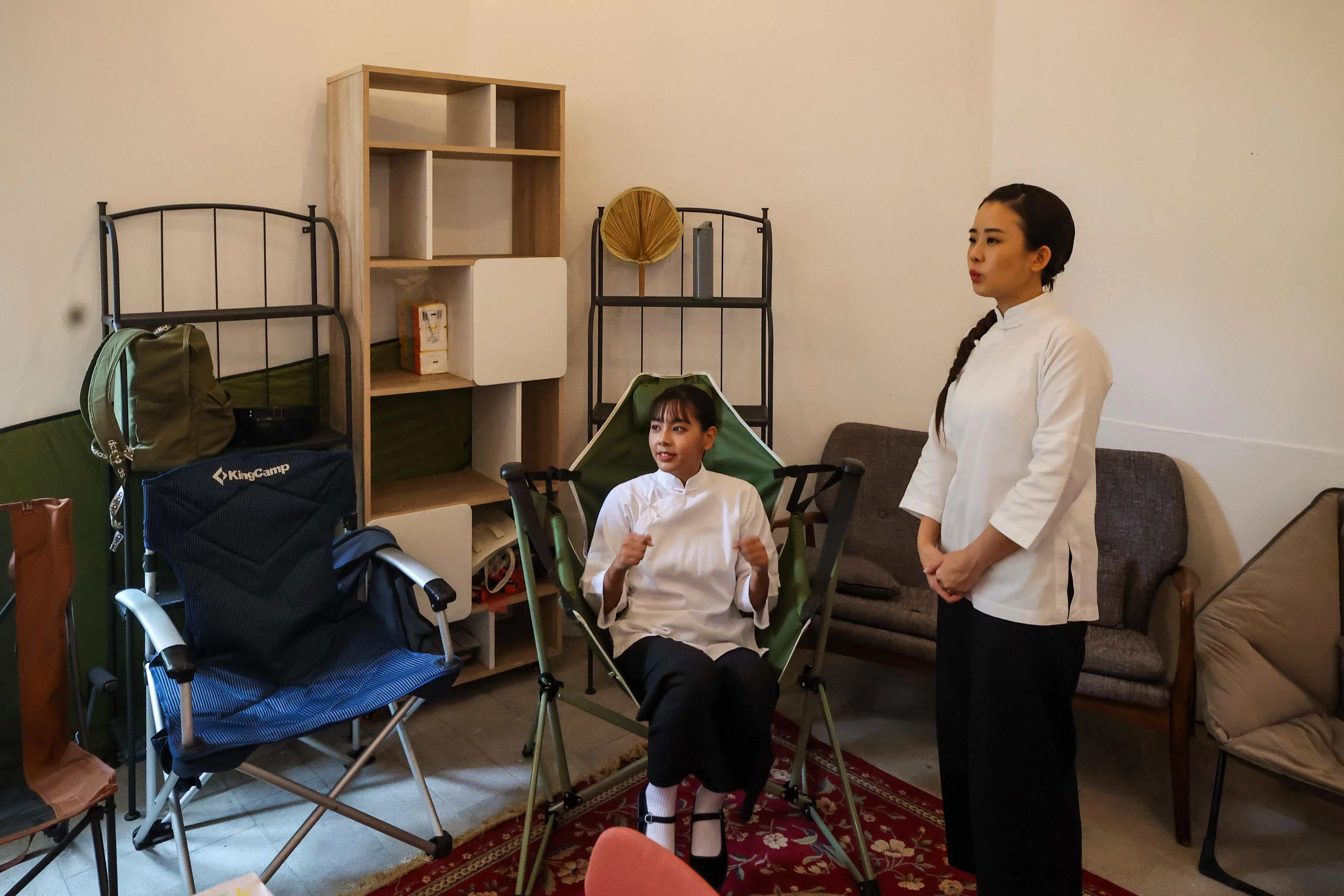 萧歆霓（左）和胡煜诗介绍有冷气的演员休息室，以及演员的专属椅子，记者仿佛在看“妈姐版”带货直播。（陈斌勤摄）