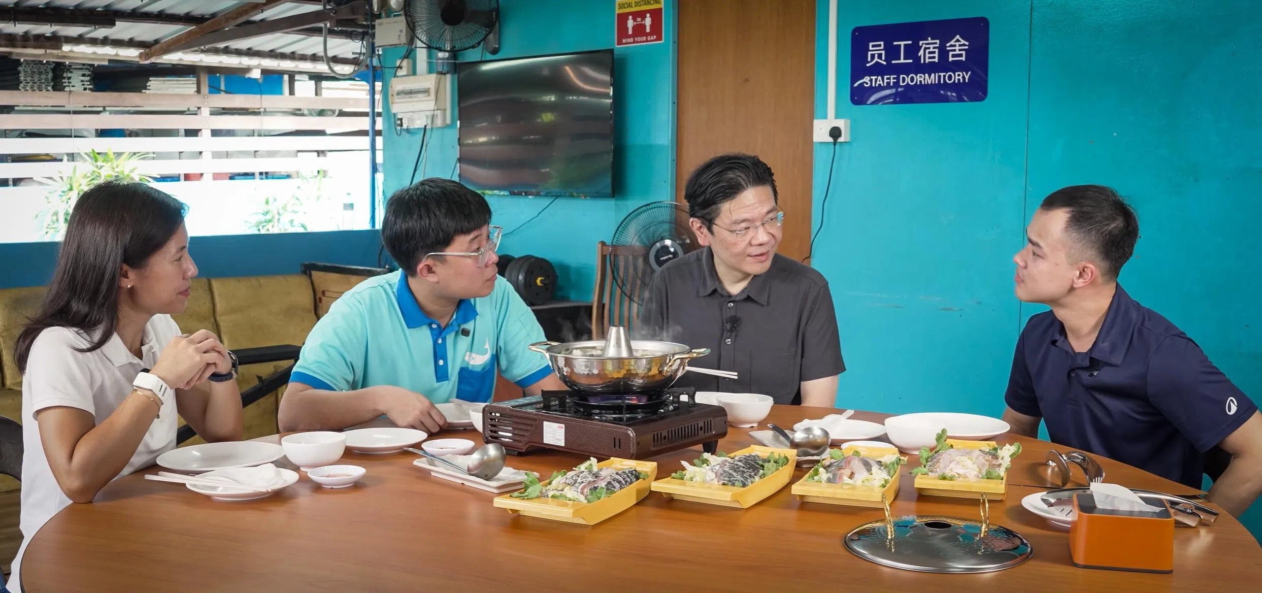 黄循财总理（右二）和文化、社区及青年部兼永续发展与环境部高级政务次长吴函燕（左一）参观鱼场后，与百美水产养殖的公司主管陈永毅（右一）和鱼场助理主任何家昇（左二）一起用餐，享用鱼场养殖的鲜鱼。（取自黄总理Youtube视频截图）