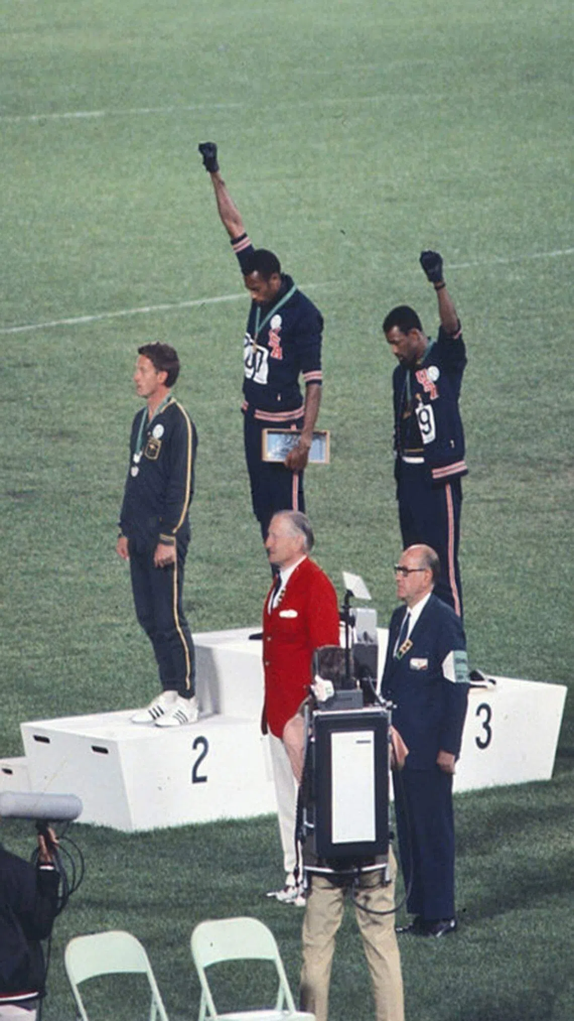 在1968年奥运会颁奖仪式上，金牌得主汤米·史密斯（中）和铜牌得主约翰·卡洛斯（右）举起一只戴着黑色手套的拳头，抗议公民权利不公正的问题。（互联网）