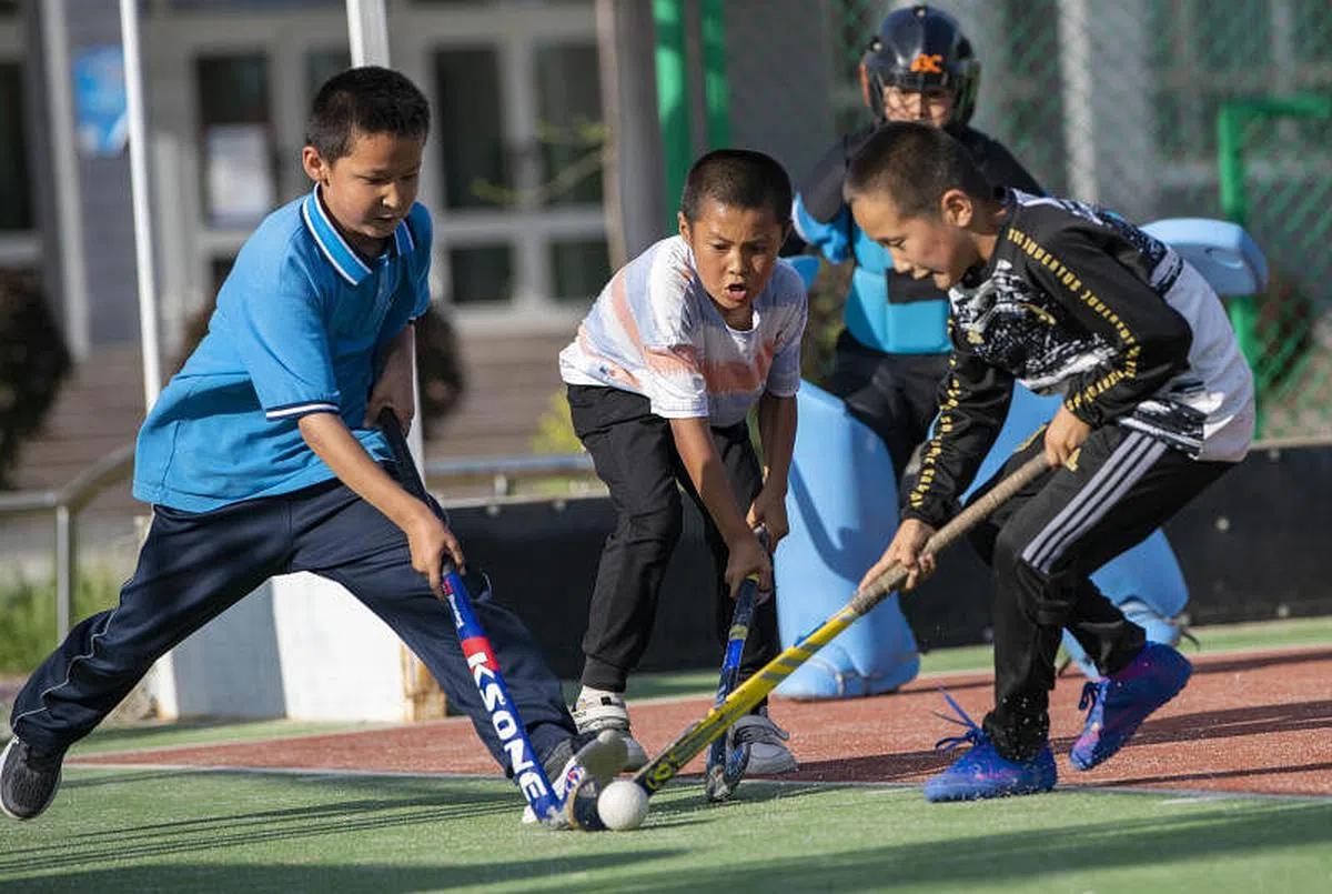 6月11日，新疆塔城市一所小学的几名学生进行曲棍球训练。（新华社）