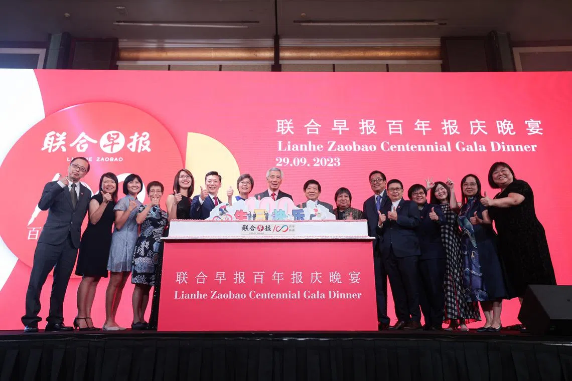 《联合早报》百年报庆晚宴9月29日在香格里拉大酒店举行，主宾李显龙总理（左八）在切蛋糕仪式后，同新报业媒体和《联合早报》高层合照留念。左起：《联合早报》副总编辑王彼得、副总编辑郭思满、助理总编辑洪奕婷、副总编辑吴新慧、华文媒体集团营运总编辑罗文燕、《联合早报》总编辑吴新迪、华文媒体集团社长李慧玲、新报业媒体主席许文远、总裁张丽琳、《联合早报》前总编辑林任君、《联合早报》执行总编辑韩咏梅、副总编辑韩咏红、副总编辑兼副刊主任胡文雁、助理总编辑谭德婷，以及助理总编辑郭丽娟。（李冠卫摄）