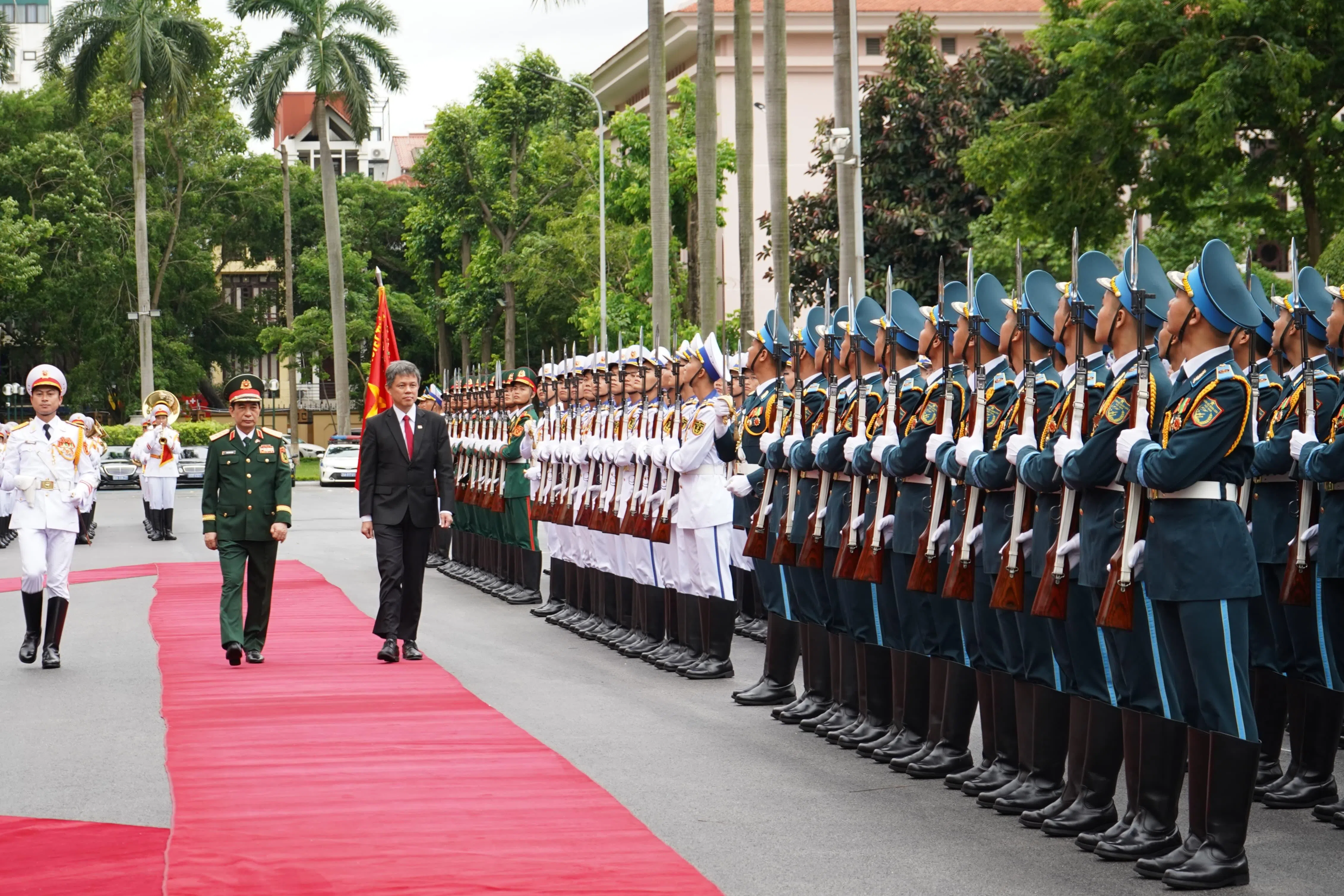 在越南进行访问的公共服务统筹部长兼国防部长陈振声（左三），星期二在越南防长潘文江上将（左二）的陪同下，于越南国防部总部检阅仪仗队。（新加坡国防部提供）