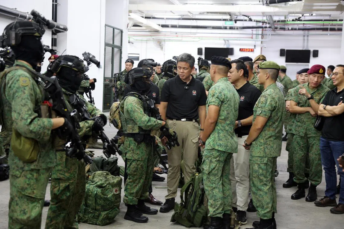 陆军速应部队是一支能执行各种任务的精锐部队，可同武装部队其他特遣队，以及内政团队的不同机构协同配合，完成反恐和救灾等任务。演习开始前，公共服务统筹部长兼国防部长陈振声（中，黑衣者）与全副武装的速应部队人员交流。国防部高级政务部长扎吉哈（右四，黑衣者）和新任国防部政务部长朱倍庆（陈振声右手边黑衣者，被遮挡）陪同视察。（邝启聪摄）