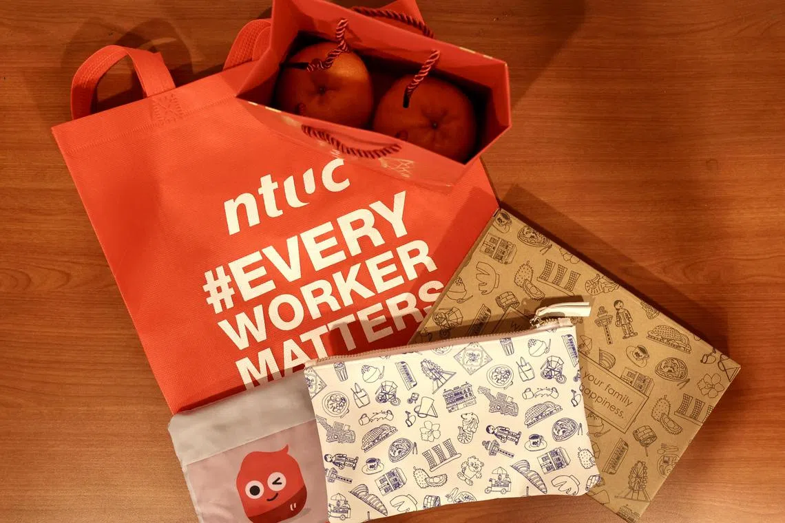 黄总理向工作人员派发礼包，以感谢他们的辛勤付出，礼包含有红包、年柑和黄总理特别准备的收纳包。（陈斌勤摄）