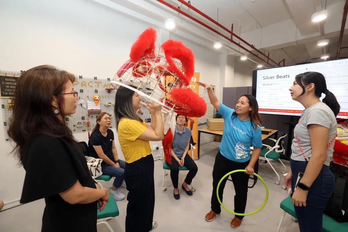 黄钰清（右二）说，她提出“游戏化舞狮”的构想，是希望通过低成本和易于推广的方式，吸引社会服务机构参与。（邝启聪摄）