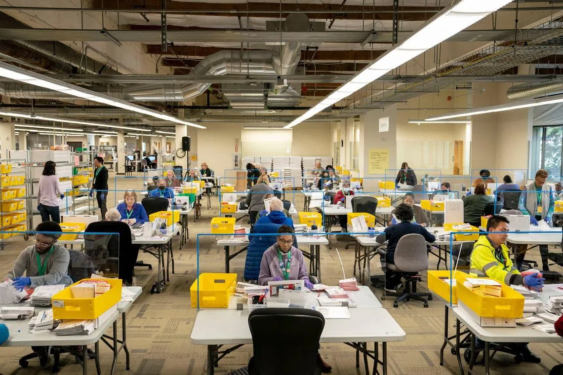 选举工作人员上周一（28日）在华盛顿州伦顿市（Renton）金县（King County）的选举总部整理选票。（彭博社）