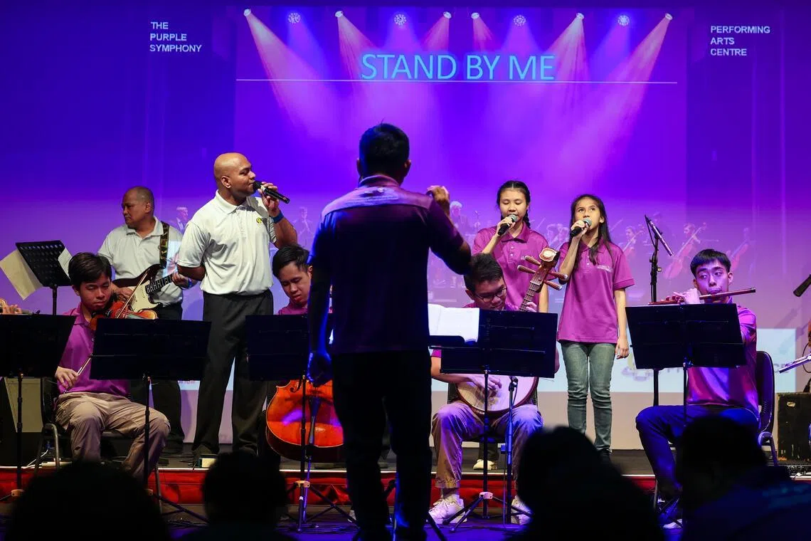 紫色交响乐团与新加坡监狱署表演艺术中心乐队首次合作。演出过程中，囚犯尤雷什（左二）不时望向与他合唱的两名紫色交响乐团的视障女生，两名女生看不见，但尤雷什相信她俩能透过自己的眼神感受到心灵上的连接。（SPH Media Limited）