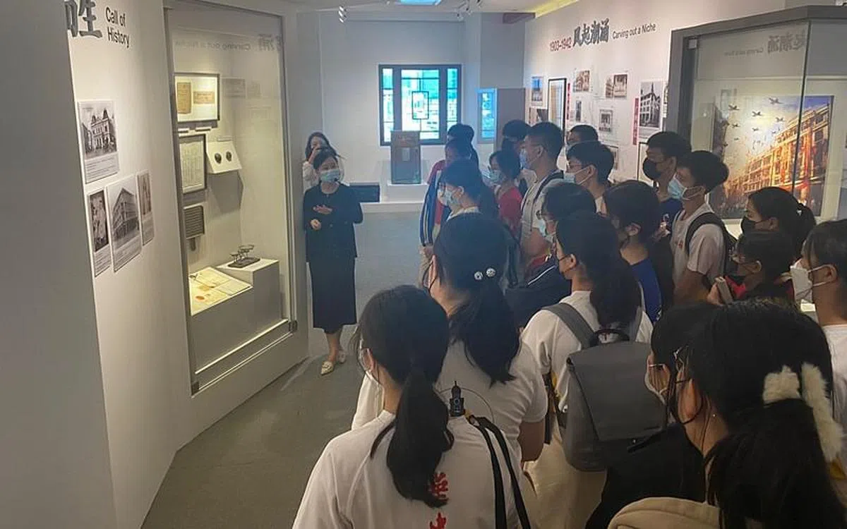 华侨中学双文化学生参观中国银行分行大厦的中新金融博览馆。（李婕摄）