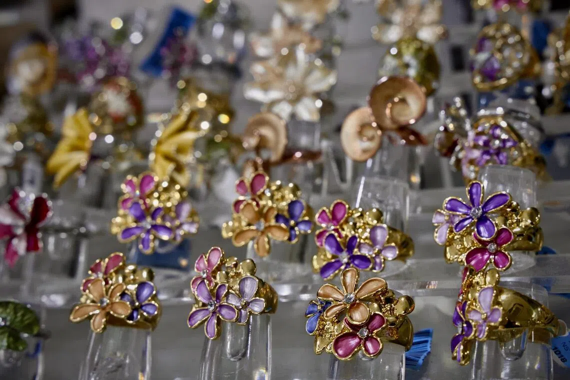 王品华设计和生产的手绘珐琅彩胡姬花首饰，色彩瑰丽。（特约陈来福摄）