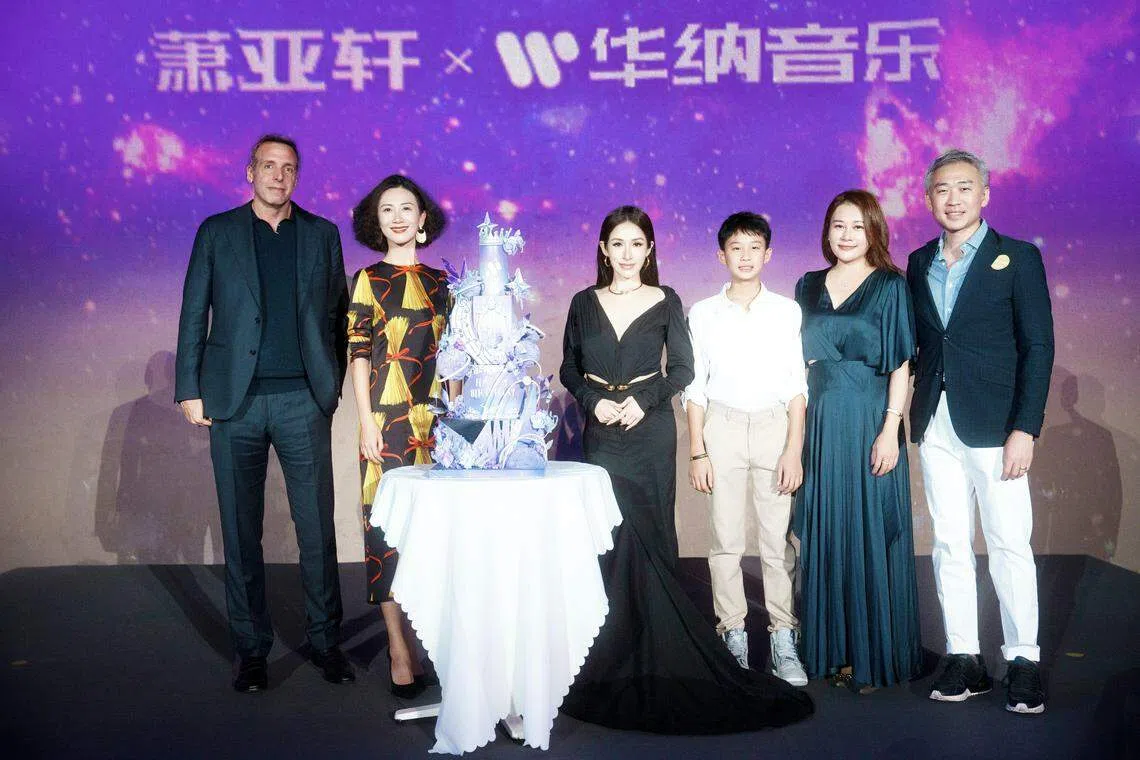 萧亚轩（右四）在北京的记者会，除了公司高层，弟弟（右一起）、弟媳和大侄儿也出席。（华纳音乐提供）