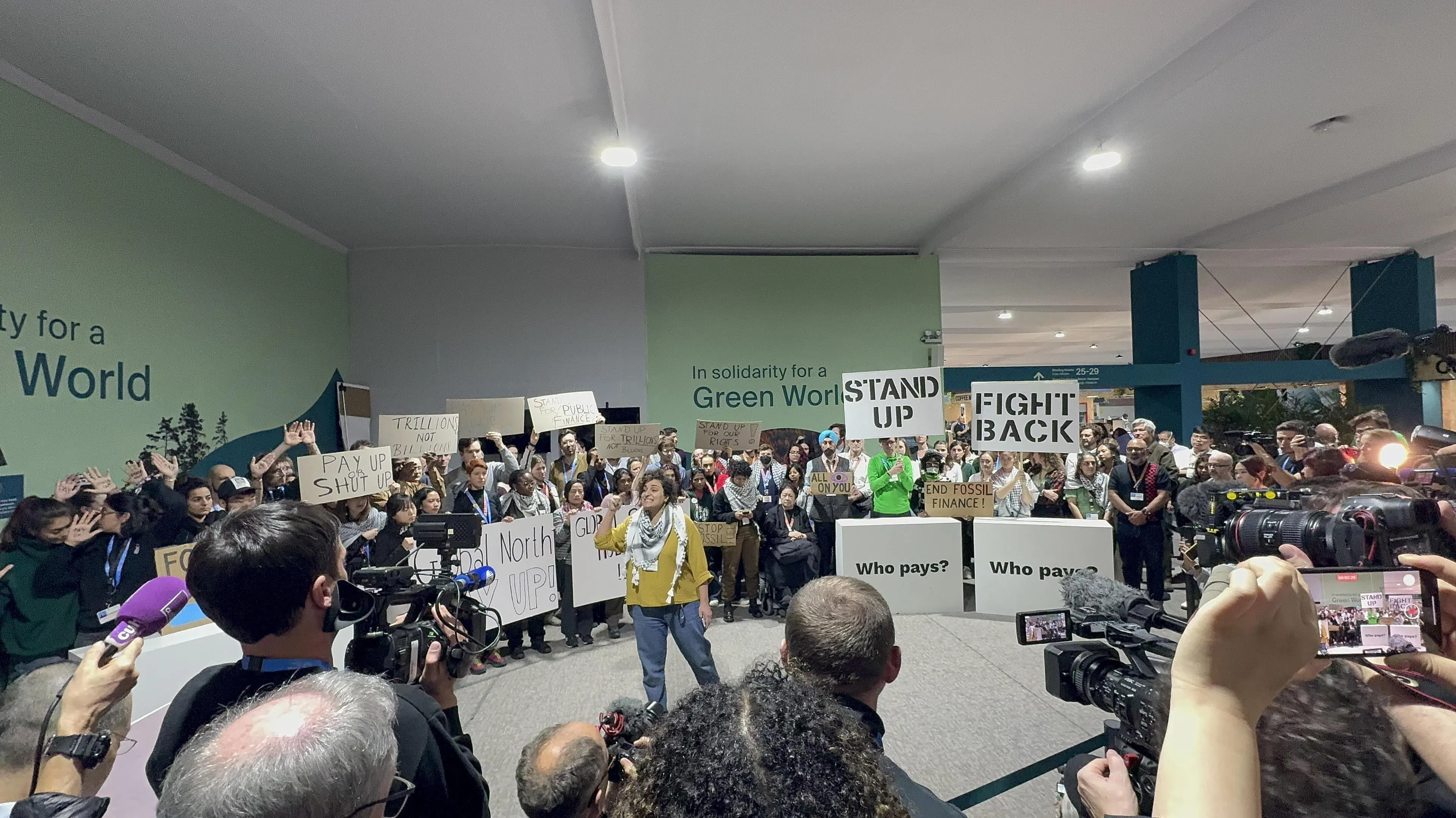 巴库当地时间星期六下午1时，50多名保育运动人士在COP29会场内抗议，认为发达国家仅拟带头拨款数千亿美元不足，应更具魄力，提高数额至数万亿美元。（蔡玮谦摄）