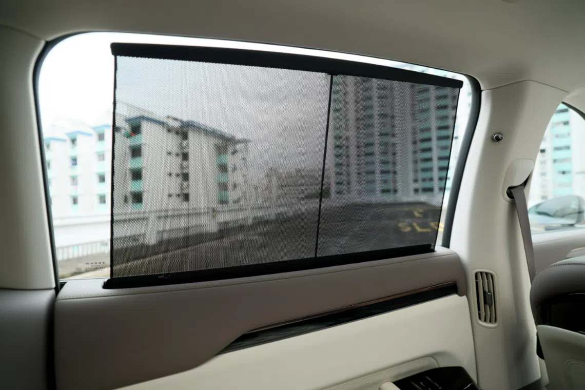 后排车门配备自动升降遮阳帘，提升乘坐舒适度。（龙国雄摄）