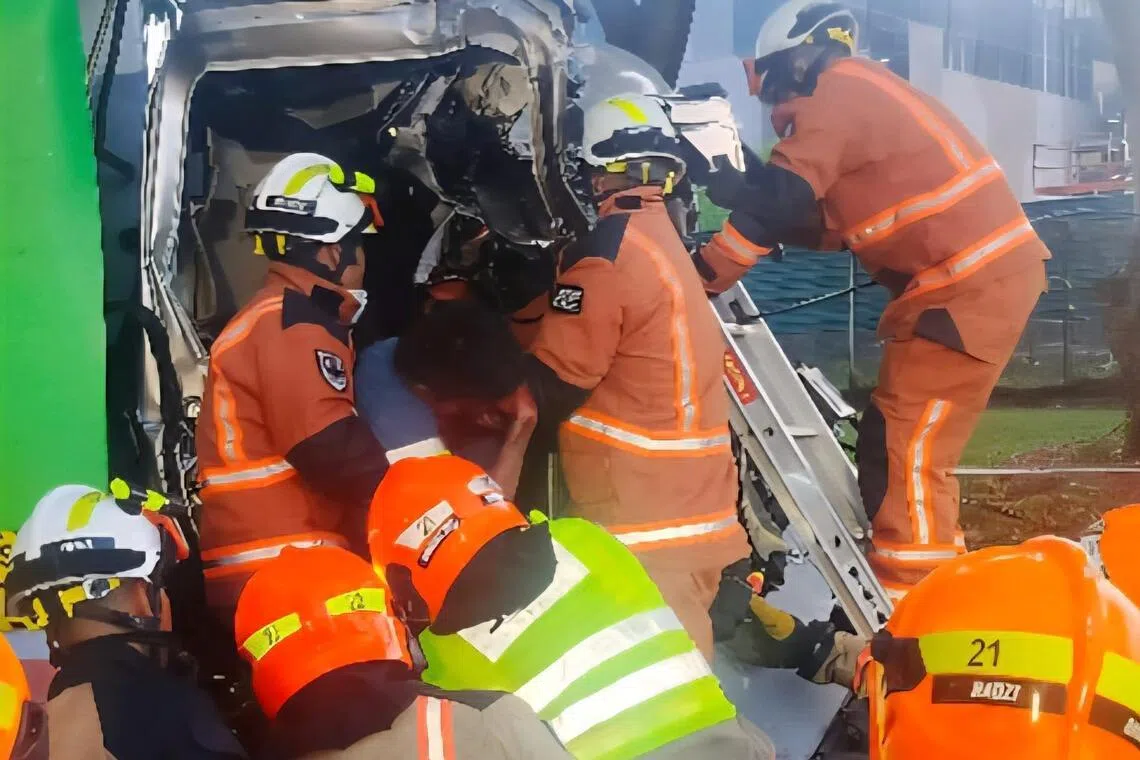 民防部队灾难拯救队队员，全力抢救被困在驾驶座的垃圾车司机。（取自民防部队脸书）