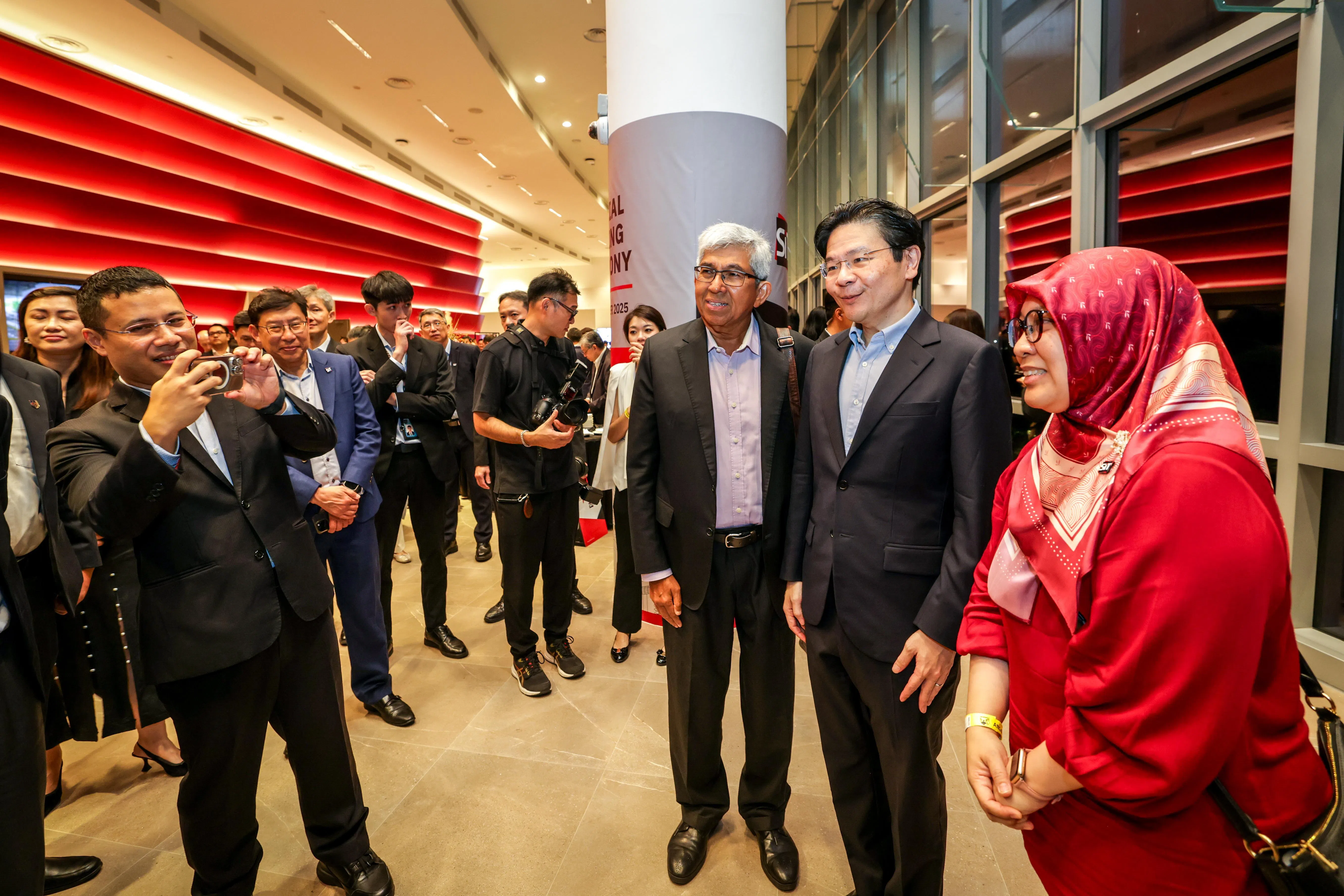 出席新加坡理工大学开幕仪式的教育部长李智陞（左一）充当“摄影师”，帮黄循财总理（右二）与前内阁部长雅国博士（右三）和前议员殷丹博士（右一）拍照留影。雅国博士是新工大顾问，殷丹博士则是新工大社区领导和社会创新中心主任。（叶振忠摄）