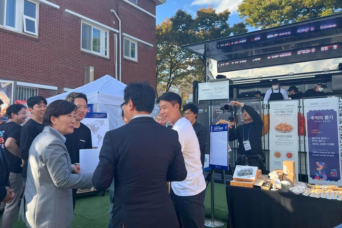 韩国农林畜产食品部长宋美玲（左一）到美食展区协助业者推广韩食。（姜贵瑛摄）