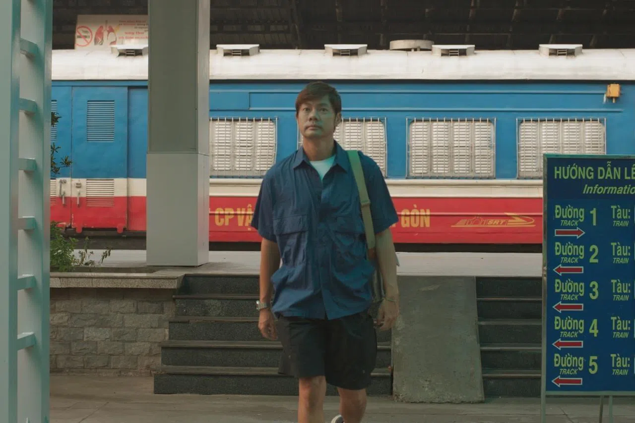 杨君伟在越南河“火车站街”，体验与火车擦肩的惊险瞬间。 （杨君伟提供）