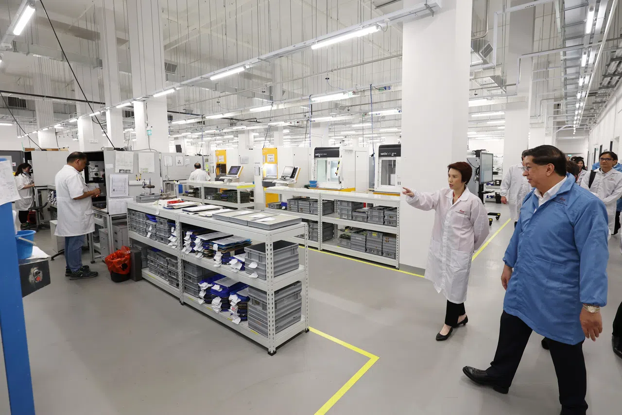 贸工部兼文化、社区及青年部政务部长刘燕玲（右二）在新加坡徕卡显微系统董事总经理何祖强（右一）的陪同下，参观这个新设施的生产线。（何家俊摄）