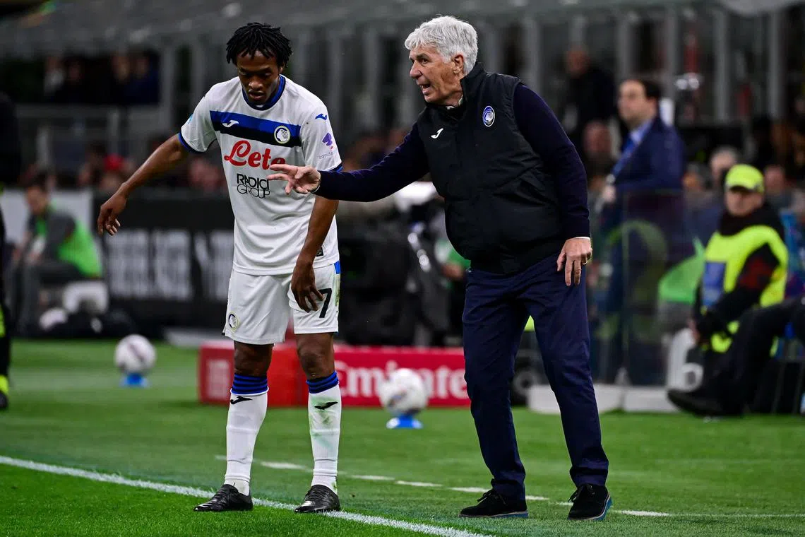 亚特兰大主帅加斯佩里尼（右）在比赛中为边锋夸德拉多（左）讲解战术。本赛季截至目前，加斯佩里尼带领球队在意甲取得了21胜八平七负的战绩。（法新社）