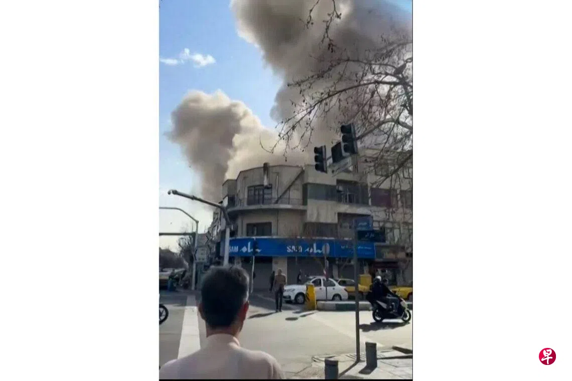 Image 15: 社交媒体视频的截图显示，2月28日，一名男子远望德黑兰发生爆炸后升起的浓烟。 （法新社）