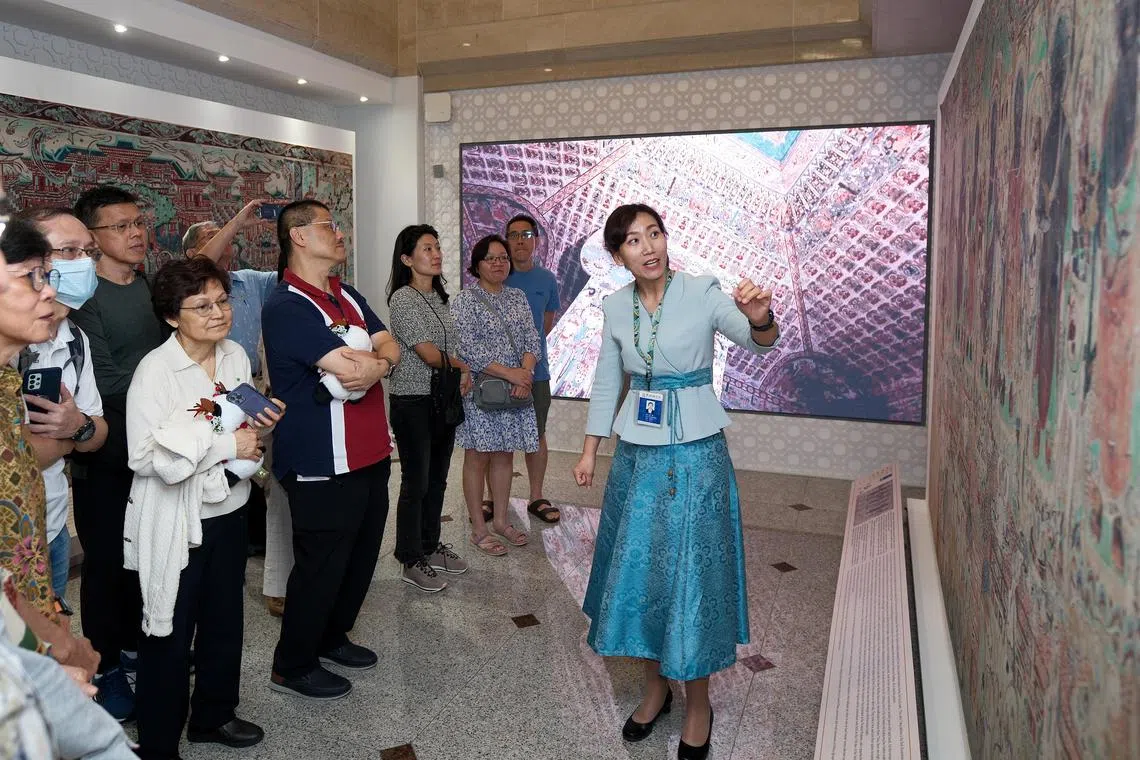 敦煌研究院资深讲解员兼助理馆员‬孟静，为大家讲解敦煌石窟艺术。（曾坤顺摄）