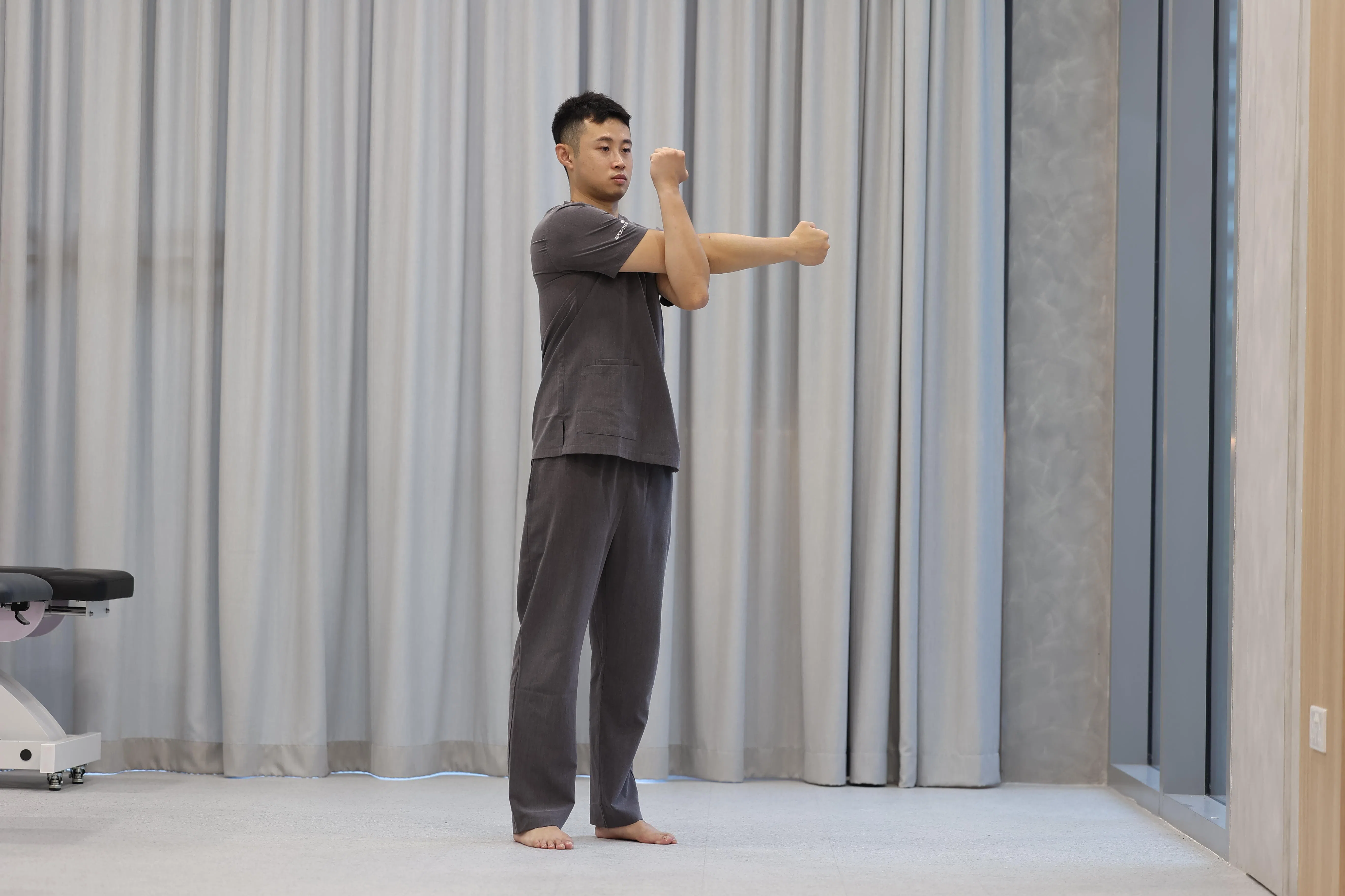 左手拉住右手臂内侧，往内牵拉，找到三角肌中束的拉伸感。（关俊威摄）