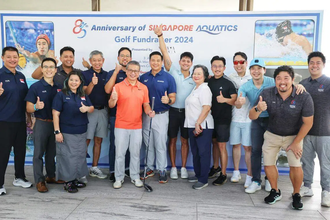 文化、社区及青年部长兼律政部第二部长唐振辉（橙衣）与约瑟林（浅蓝衣）、约瑟林母亲严锦美（白衣）、新加坡泳联代表和财富教育学院代表合影留念。（萧紫薇摄）