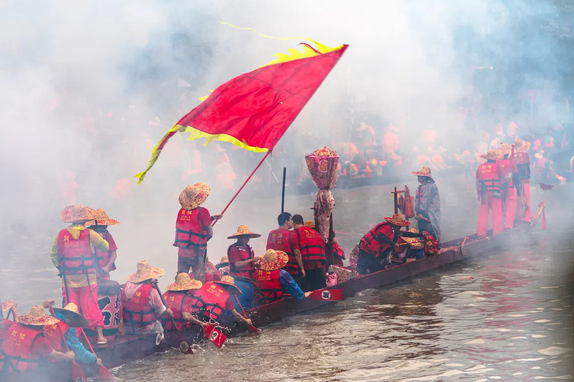 旗手挥动彩旗，为竞渡的勇士们指引方向，助威壮势。（车陂）（蔡光发摄）