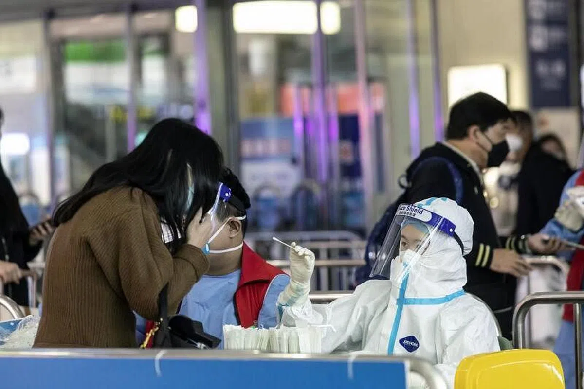 在上海虹桥火车站，一名乘客在11月23日接受核酸检测。（彭博社）