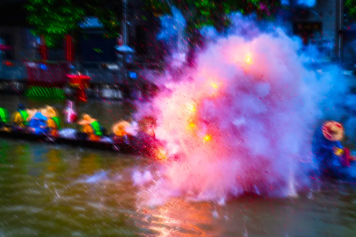 鞭炮声震耳欲聋，仿佛要撕裂江面，火光与硝烟在空气中激烈飞扬。（车陂）（蔡光发摄）