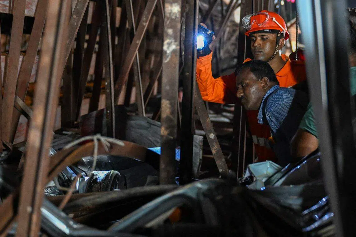 事故现场有一个汽油泵，印度全国救灾应急部队和救援人员必须小心翼翼地进行搜救。（法新社）