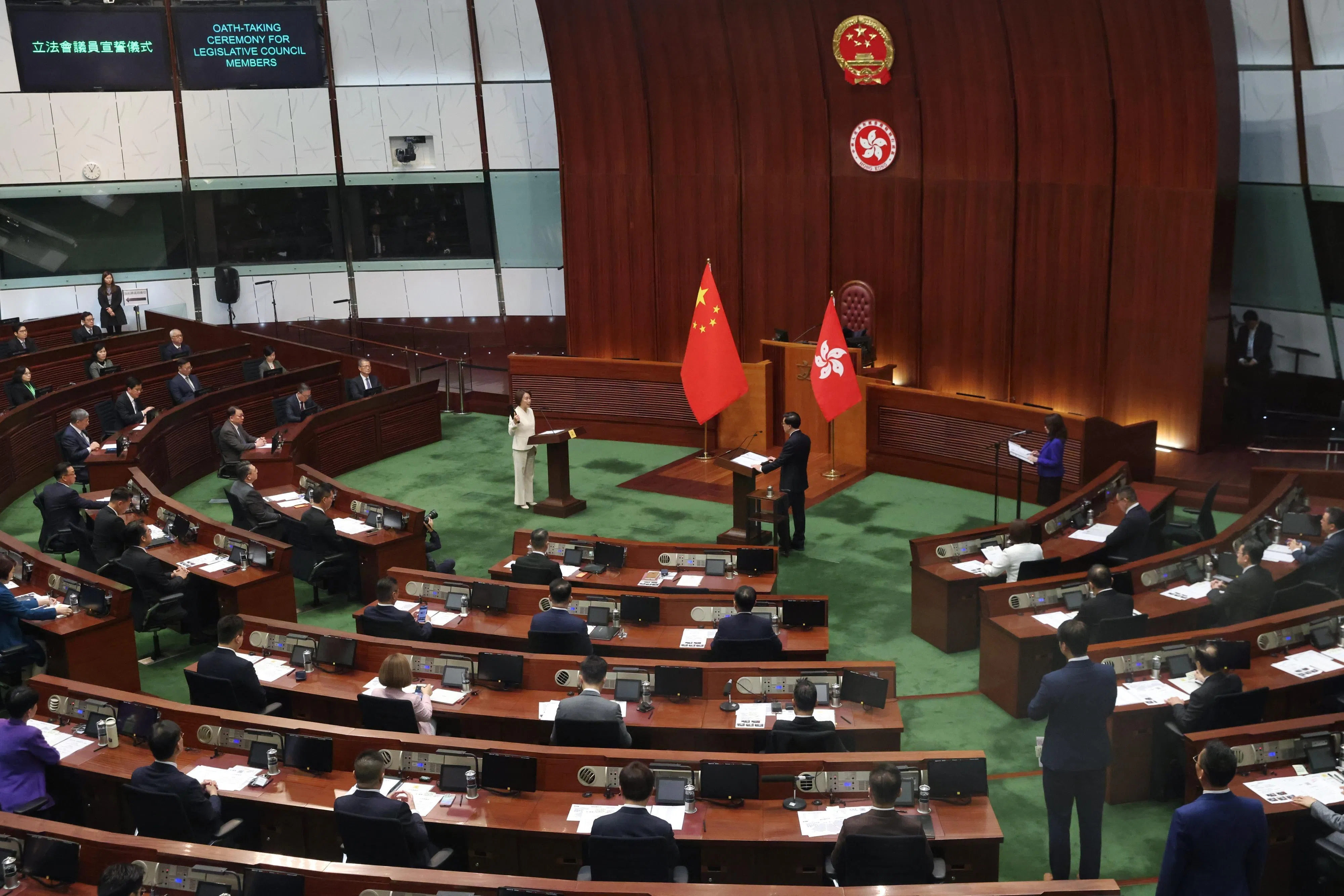 李家超1月1日在为议员监誓期间全程站立一个多小时，身旁茶几边有一支拐杖。（中通社）