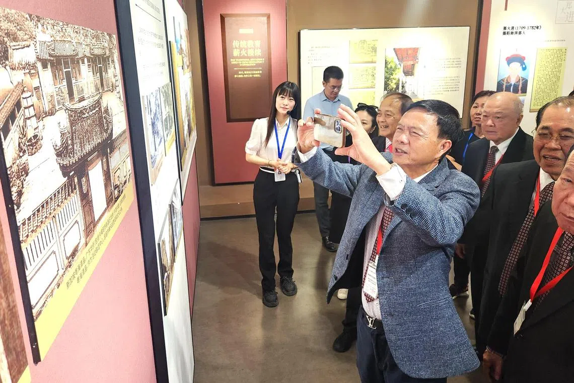 参观揭阳博物馆时，潮州总会会长张建安（前）看到熟悉的新加坡粤海清庙，连忙拿出手机拍下。（陈爱薇摄）