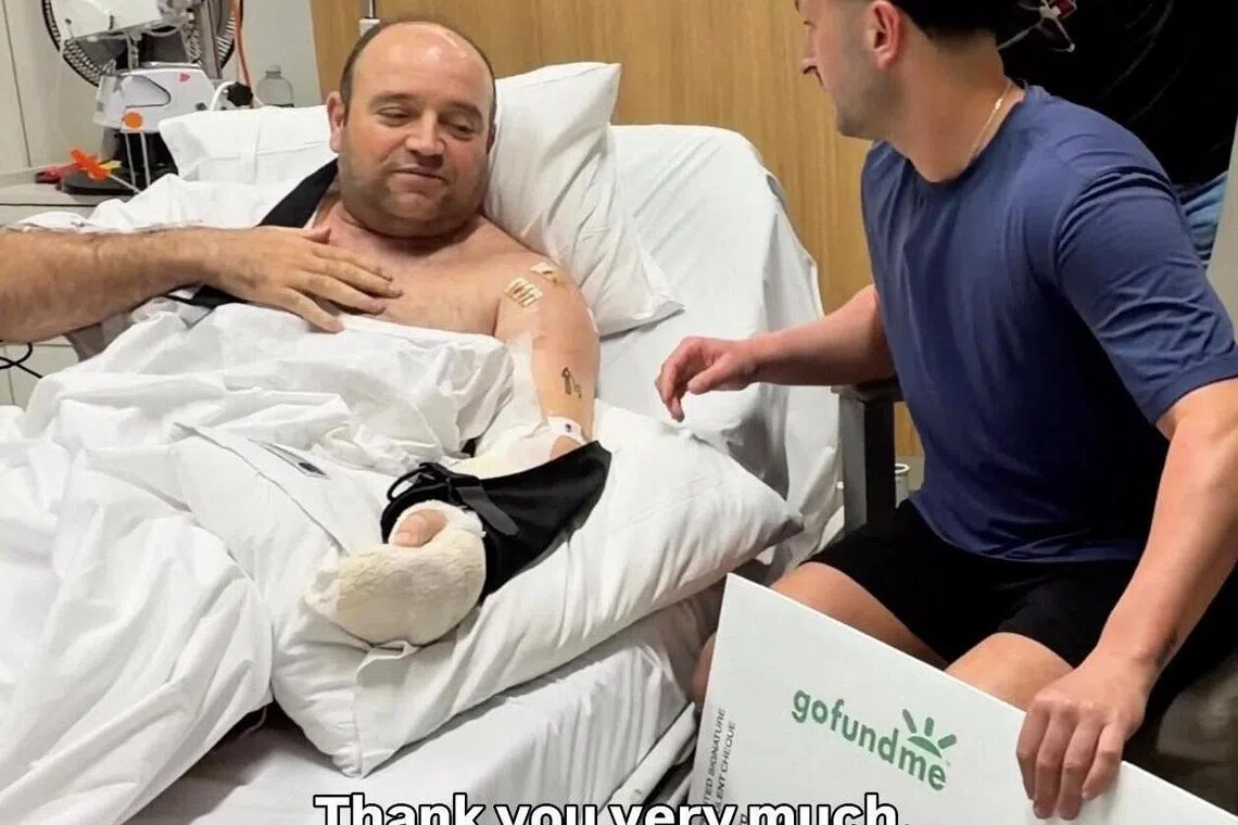 12月19日，GoFundMe募捐页面联合发起人德雷尼奥夫斯基（右），将一张超过250万澳元（约213万新元）的支票，交给病床上的艾哈迈德，后者表明，希望所有人都能彼此支持。（取自德雷尼奥夫斯基社媒主页@mdmotivator）