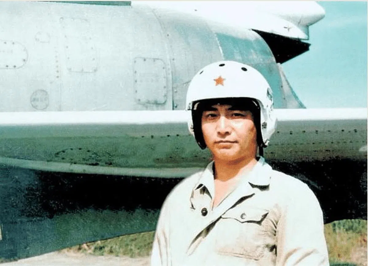 王伟生前在战机前留影。（互联网）