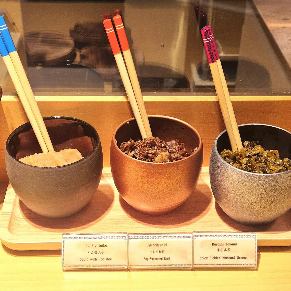 餐馆提供免费小菜，如明太子鱿鱼、酱油焖牛肉、辣渍高菜。（陈爱薇摄）