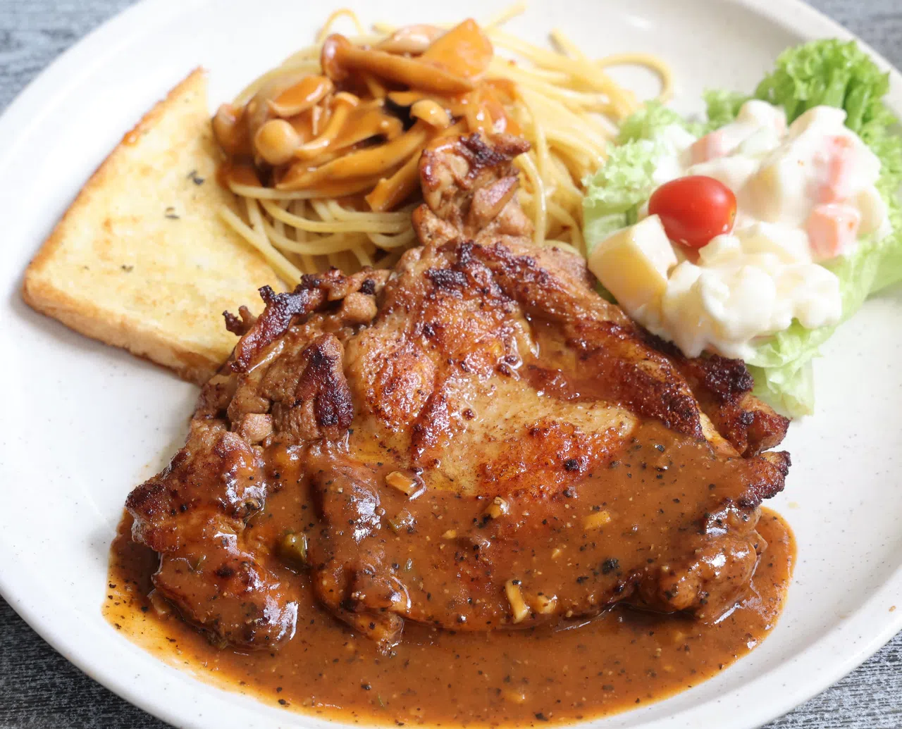 Grandpa阿公西餐的鸡扒，搭配意大利面与日式马铃薯沙拉。（邬福梁摄）