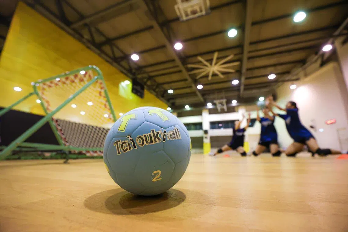 2号巧固球通常用于大专级别比赛。画面背景中三人防守正准备接球。（游甯稀摄）