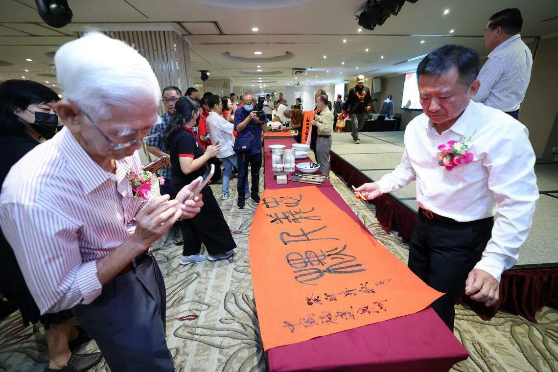 来自中国福建泉州的民俗画家曾成聪（右）现场挥毫。（林明顺摄）