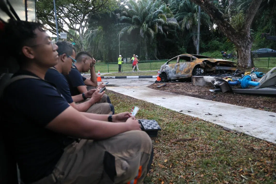 火势被扑灭后，警方留在现场指挥交通，消防人员在路旁稍作休息。（张俊杰摄）