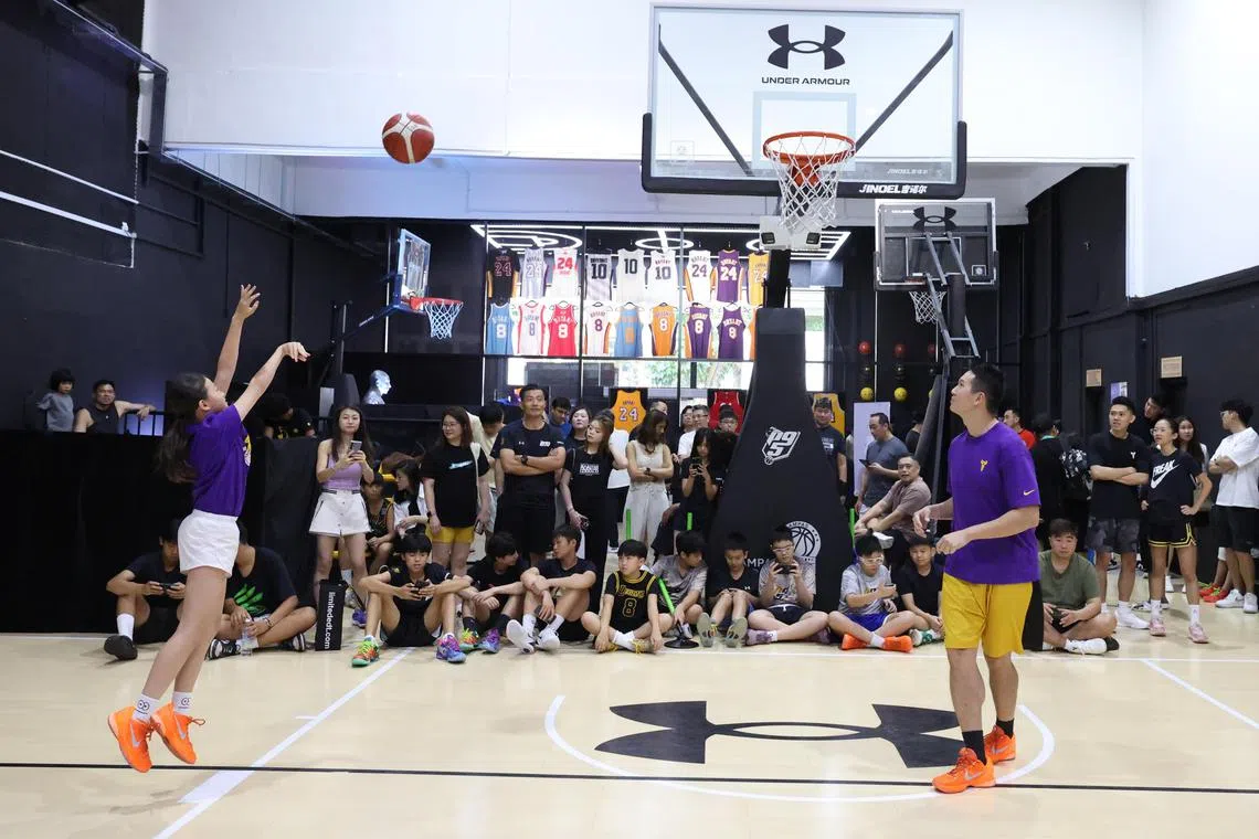 黎瑞恩（左）在比赛中投篮出手，和父亲黎威杰（右）一起上场。（梁麒麟摄）
