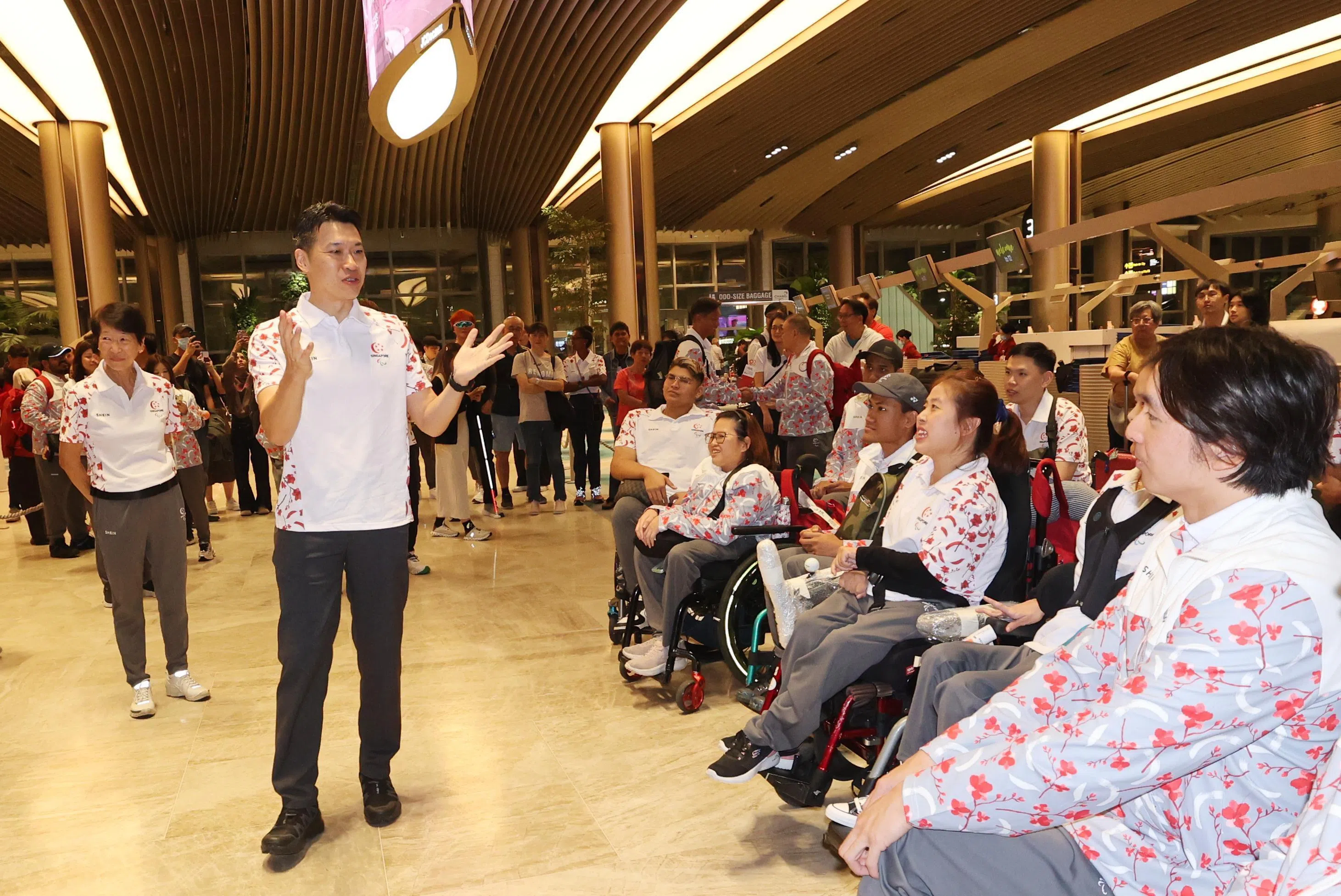 文化、社区及青年部代部长梁振伟在机场为我国残障健儿们加油打气。（邬福梁摄）