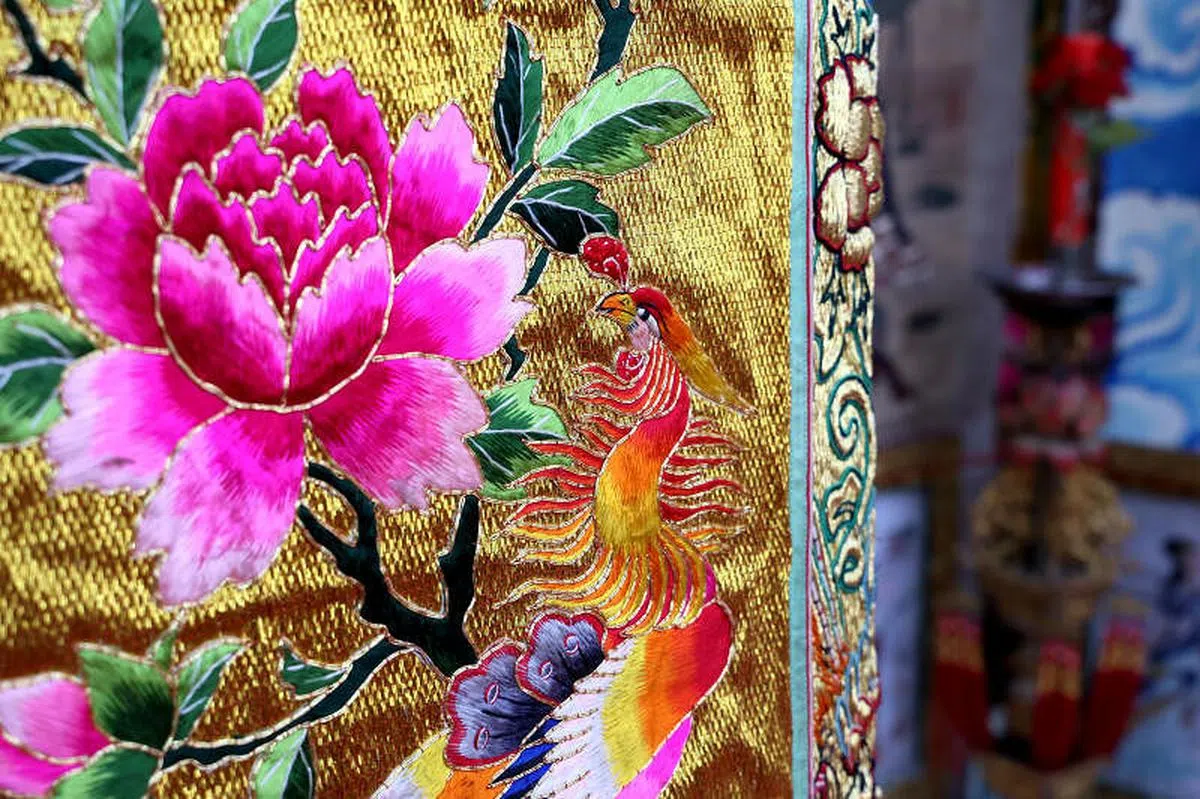金线为底的潮绣手工精细，由老师傅一针一线缝制， 不用热熔胶粘合。（龙国雄摄）
