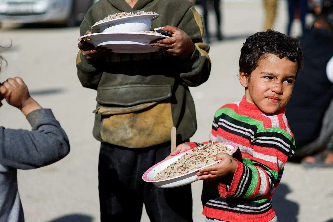 加沙地带的巴勒斯坦如今几乎全都流离失所。在南部拉法的帐篷营地，居民依靠慈善组织提供的粮食度日。（路透社）