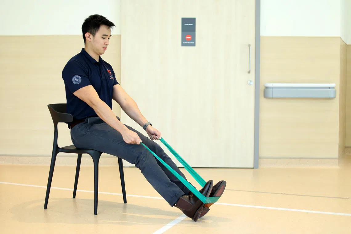 物理治疗师陈行杰示范以阻力带做运动，他说阻力训练对改善肌肉量和骨头强度有很大的帮助。（龙国雄摄）